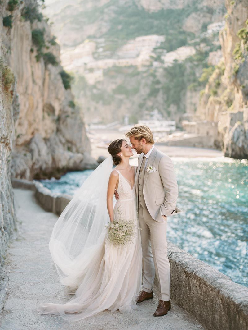 Bride and groom on a coastal cliffside, editorial destination wedding portrait by Michigan Luxury Weddings